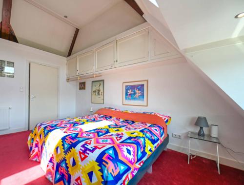 a bedroom with a bed with a colorful comforter at Xaviera's Bed and Breakfast in Amsterdam