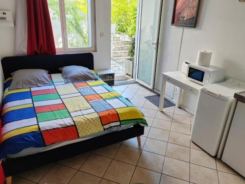 ein Schlafzimmer mit einem Bett und einem TV auf einem Fliesenboden in der Unterkunft Chambre meublée indépendante, avec piscine et jardin, 1 lit pour 2 personnes in Toulouse