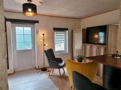 a living room with a table and chairs and a television at Love Room avec spa in Nérac