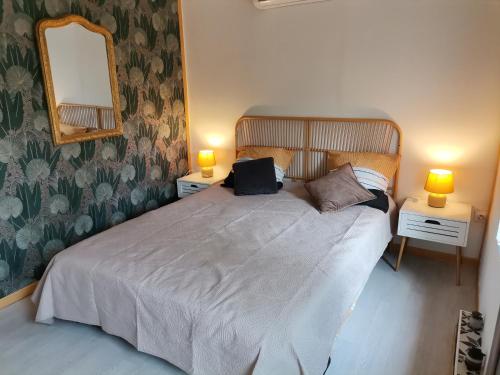 a bedroom with a bed with two lamps and a mirror at Love Room avec spa in Nérac