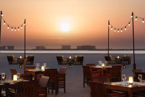 a restaurant on the beach at sunset at The Ritz-Carlton Ras Al Khaimah, Al Hamra Beach in Ras al Khaimah