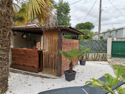a small wooden building with plants in a yard at Love Room avec spa in Nérac