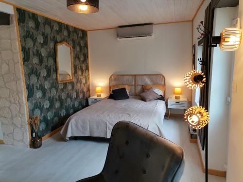 a bedroom with a bed and a chair in it at Love Room avec spa in Nérac