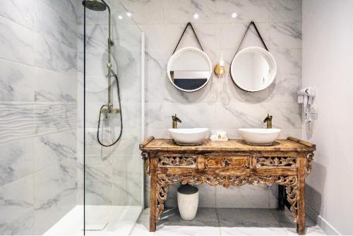 a bathroom with a vanity with two sinks and mirrors at Charmant appartement avec extérieur privatif in Sète