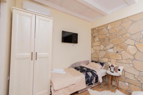 a bedroom with a stone wall and a bed at Ostroške grede in Nikšić