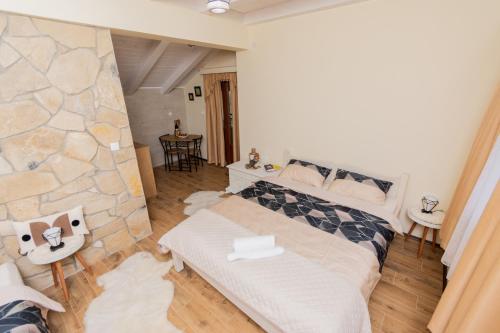 a bedroom with a bed and a stone wall at Ostroške grede in Nikšić