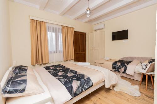 a bedroom with two beds and a flat screen tv at Ostro&scaron;ke grede in Nik&scaron;ić