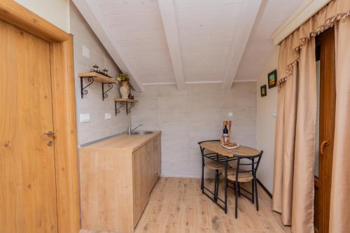 a small kitchen with a sink and a table at Ostro&scaron;ke grede in Nik&scaron;ić