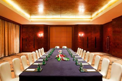 a long table in a large room with white chairs at Sheraton Shenzhen Futian Hotel in Shenzhen