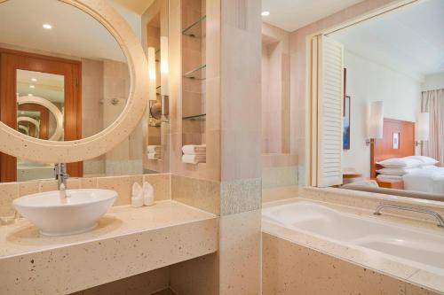 y baño con lavabo, bañera y espejo. en Sheraton Sanya Yalong Bay Resort en Sanya