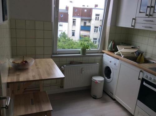 cocina con lavadora y ventana en Altbauwohnung mit viel Charme in zentraler Lage en Kiel