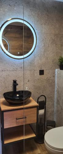 La salle de bains est pourvue d'un lavabo et d'un miroir sur une table. dans l'établissement Apartamenty Hetmańska - 24h Shop, à Katowice