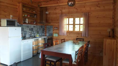 a kitchen with a table and a white refrigerator at casa entre praias in Foz do Arelho