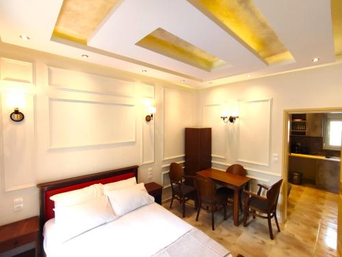 1 dormitorio con 1 cama y 1 mesa con sillas en Villa Miltiadis GreeceFyloxenia, en Volos