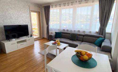 Four Views Apartments في بودفا: غرفة معيشة بها أريكة وتلفزيون