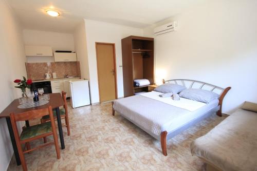 sypialnia z łóżkiem i stołem oraz kuchnia w obiekcie Apartmani Nika w Bibinje