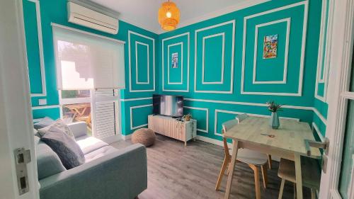 a living room with blue walls and a table and a couch at Afonso Galo Guest Apartments III in Almada