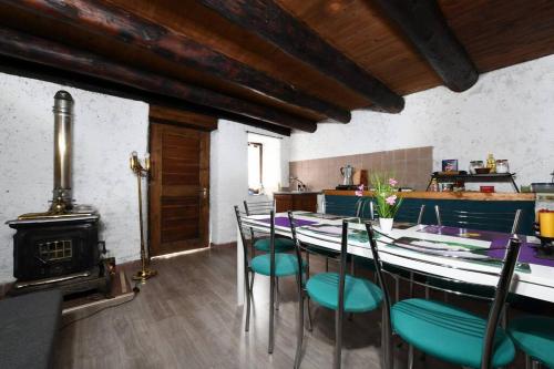 a dining room with a table and chairs and a stove at Rustico al fiume Verzasca 