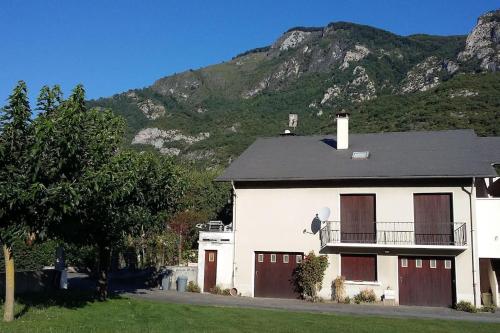 una casa blanca con una montaña en el fondo en REZ DE JARDIN AU COEUR DES PYRENEES, en Agos-Vidalos