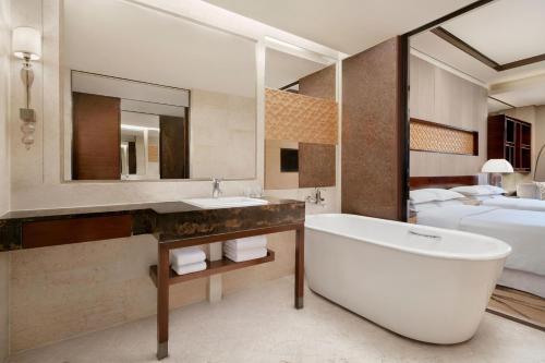 un bagno con vasca e una camera con letto di Sheraton Xi'an North City Hotel a Xi'an