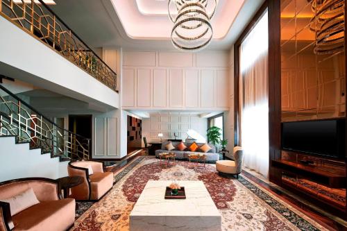 a living room with a couch and a tv at Sheraton Xi'an North City Hotel in Xi'an