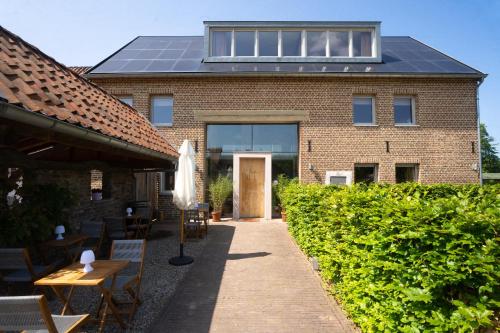 a building with a solar roof and tables and chairs at TweeZeven in Guelle