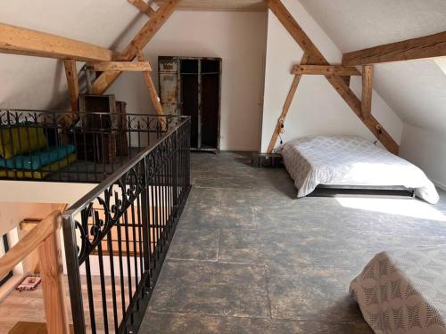 um quarto no sótão com uma cama e uma escada em Le grenier a foin em Breitenbach-Haut-Rhin