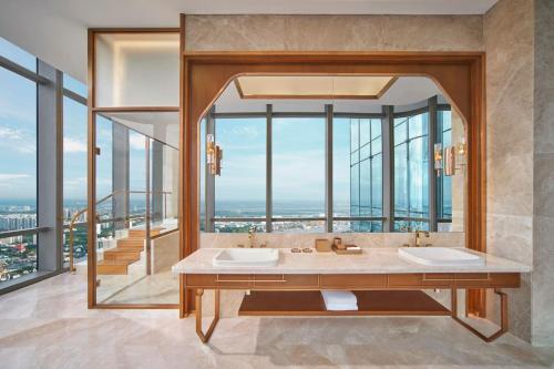 a bathroom with two sinks and a large window at Vinpearl Landmark 81, Autograph Collection in Ho Chi Minh City
