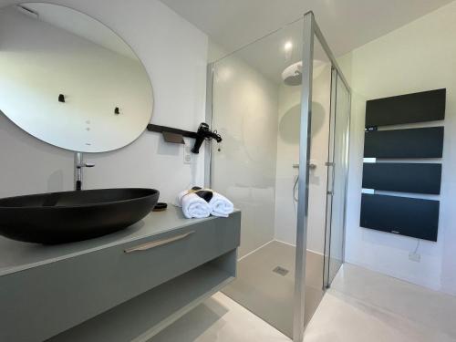 a bathroom with a black sink and a mirror at Le Clos Des Buis Gîte de Charme Cocoonoïte in Cazals