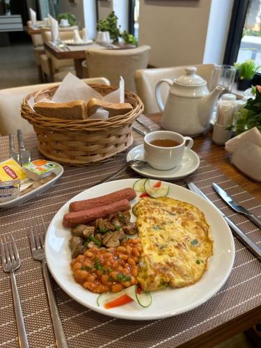 a table with a plate of food on a table at The Cabin Hotel in Accra