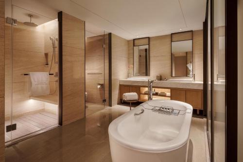 a bathroom with a white tub and a shower at The Yuluxe Sheshan, Shanghai, A Tribute Portfolio Hotel in Songjiang