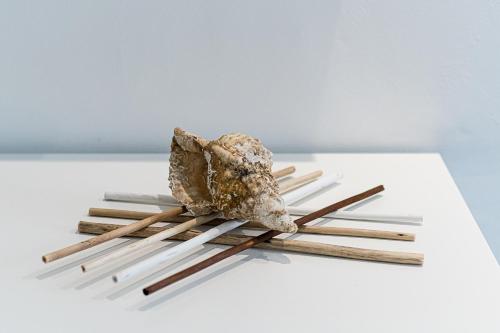 a piece of meat on a pile of wooden chopsticks at Un Posto al Mare in Santa Maria di Castellabate