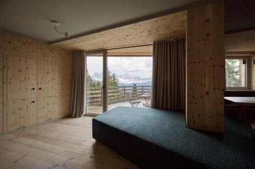 布列瑟農的住宿－Odles Lodge，一间卧室设有一张床和一个大窗户