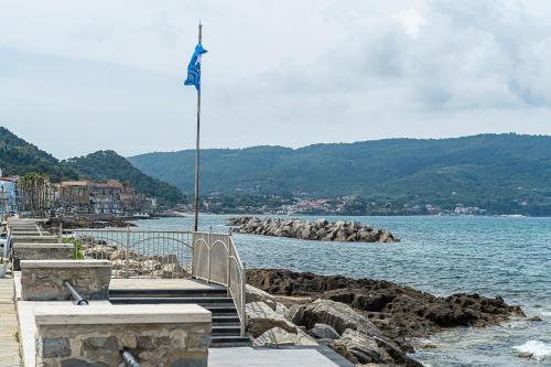a flag on a pole next to a body of water at Un Posto al Mare in Santa Maria di Castellabate