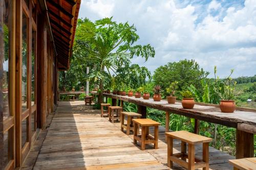 a long wooden walkway with benches and tables at Mộc An Nhiên Farmstay in Pleiku