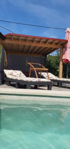 two beds under a picnic table next to a swimming pool at Studio-Apartman-Diana in Brseč