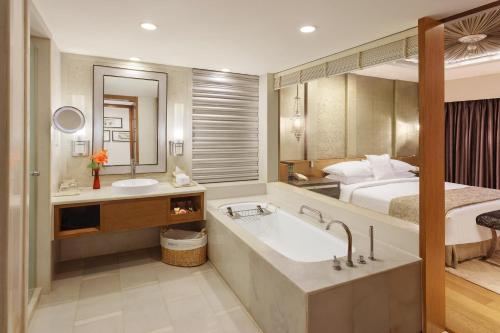 uma casa de banho com uma banheira grande e uma cama em ITC Mughal, A Luxury Collection Resort & Spa, Agra em Agra