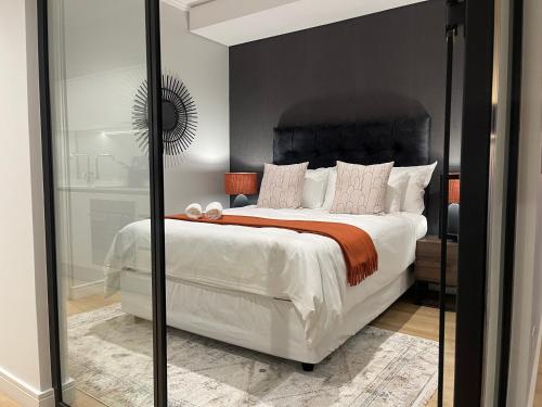 a bedroom with a large bed and a mirror at Exec Oasis @Ellipse in Midrand