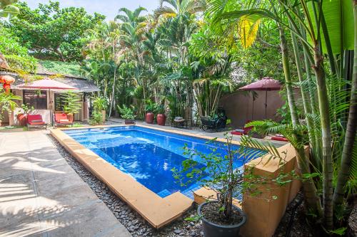 a swimming pool in a yard with plants at Maison 557 in Siem Reap
