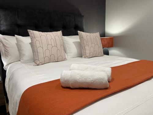 a large white bed with a brown blanket and pillows at Exec Oasis @Ellipse in Midrand