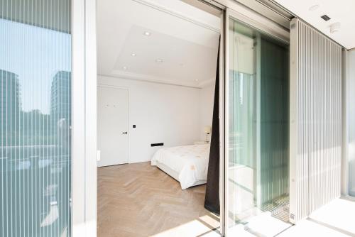 a bedroom with a bed and a glass window at Battersea Mall apartment in London