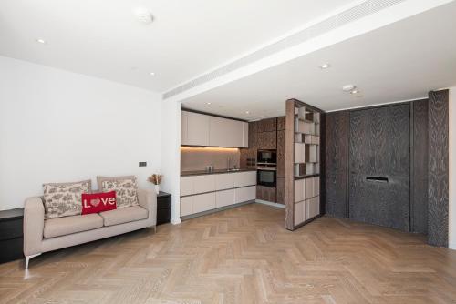 a living room with a couch and a kitchen at Battersea Mall apartment in London