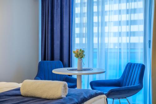 a table with blue chairs and a table with a vase of flowers at Batumi River Source in Batumi