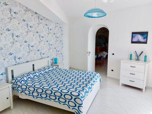 a bedroom with a bed with a blue and white comforter at Villa Carmela in Conca dei Marini