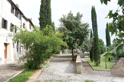 una calle adoquinada con árboles y un edificio en SAILA Monolocale VENERE, en Attigliano