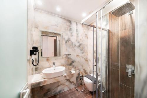 ein Badezimmer mit Waschbecken, Toilette und Dusche in der Unterkunft Brothers Apartments in Skala Potamias