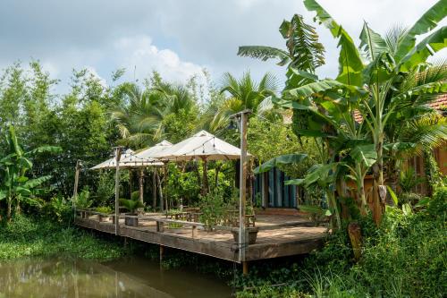 a house on a dock in the middle of a river at Mộc An Nhiên Farmstay in Pleiku