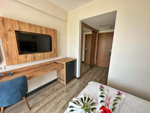 a room with a flat screen tv on a wall at KAYA GARDEN OTEL in Side