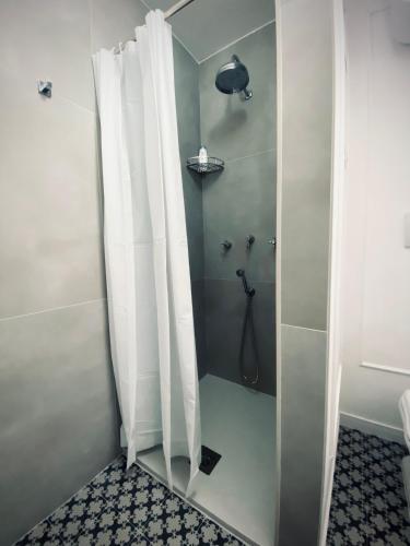 a shower with white curtains in a bathroom at AVòS in Polignano a Mare