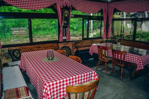 a restaurant with a red and white checkered table and chairs at Villa Tasnim in Dobrenica